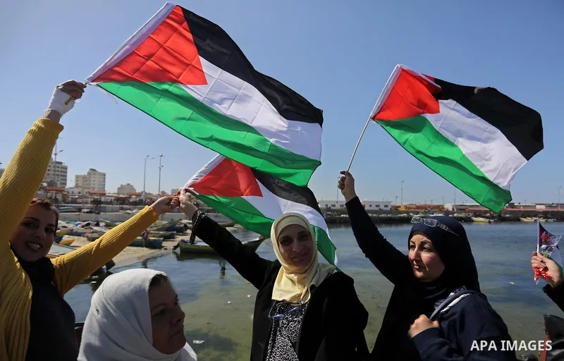 Palestinian women throw letters and flowers during a demonstration marking International Women's Day, in Gaza City on March 9, 2017. Photo by Ashraf Amra