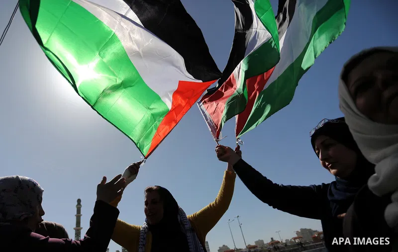 Palestinian women throw letters and flowers during a demonstration marking International Women's Day, in Gaza City on March 9, 2017. Photo by Ashraf Amra