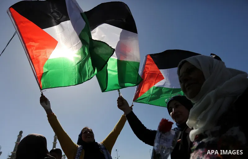 Palestinian women throw letters and flowers during a demonstration marking International Women's Day, in Gaza City on March 9, 2017. Photo by Ashraf Amra