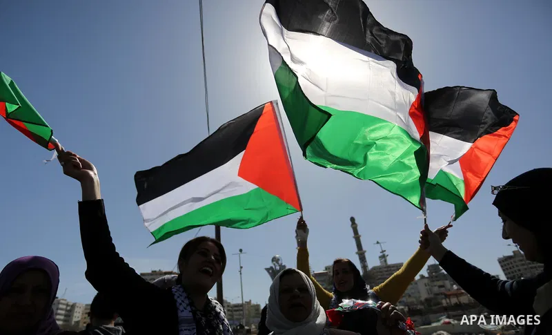 Palestinian women throw letters and flowers during a demonstration marking International Women's Day, in Gaza City on March 9, 2017. Photo by Ashraf Amra
