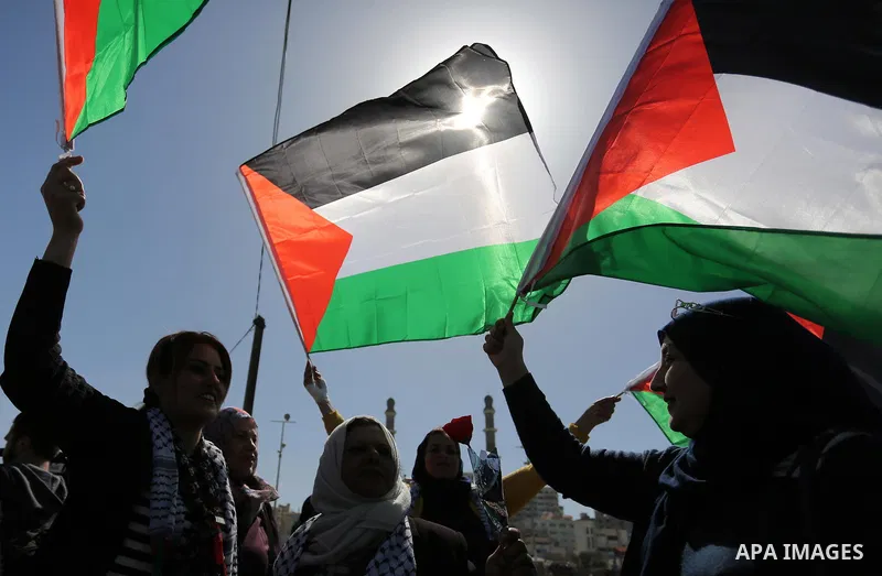 Palestinian women throw letters and flowers during a demonstration marking International Women's Day, in Gaza City on March 9, 2017. Photo by Ashraf Amra