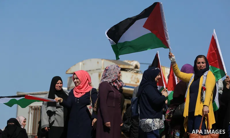 Palestinian women throw letters and flowers during a demonstration marking International Women's Day, in Gaza City on March 9, 2017. Photo by Ashraf Amra