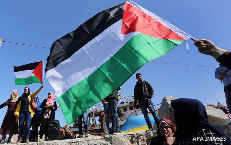 Palestinian women throw letters and flowers during a demonstration marking International Women's Day, in Gaza City on March 9, 2017. Photo by Ashraf Amra