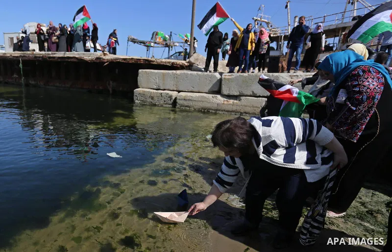 Palestinian women throw letters and flowers during a demonstration marking International Women's Day, in Gaza City on March 9, 2017. Photo by Ashraf Amra