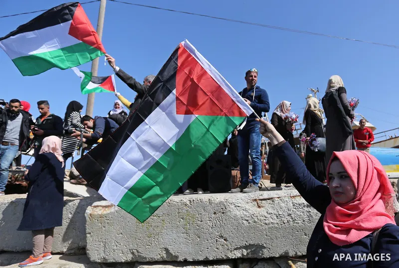 Palestinian women throw letters and flowers during a demonstration marking International Women's Day, in Gaza City on March 9, 2017. Photo by Ashraf Amra