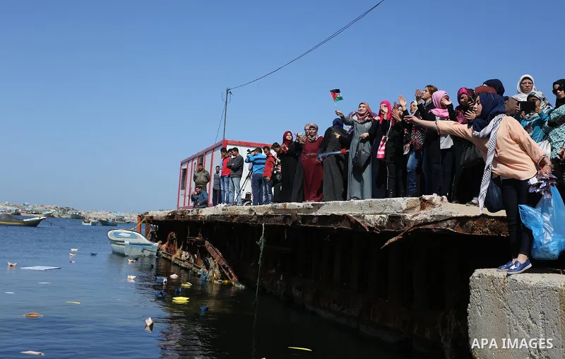 Palestinian women throw letters and flowers during a demonstration marking International Women's Day, in Gaza City on March 9, 2017. Photo by Ashraf Amra
