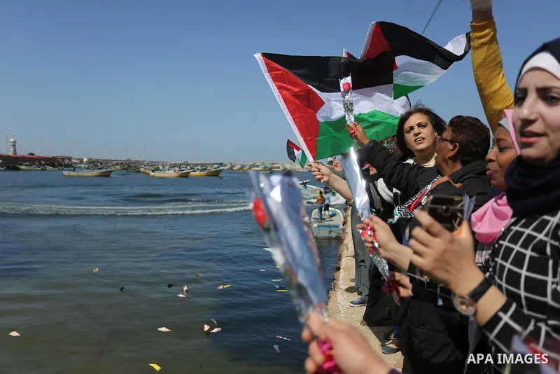 Palestinian women throw letters and flowers during a demonstration marking International Women's Day, in Gaza City on March 9, 2017. Photo by Ashraf Amra