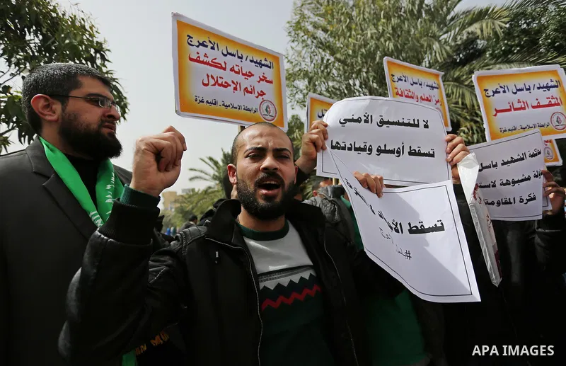 Palestinian supporters of the Popular Front for the Liberation of Palestine (PFLP), hold placards during a protest against the trial of the martyr, Bassel al-Aaraj, and the security coordination in Gaza City, on March 12...