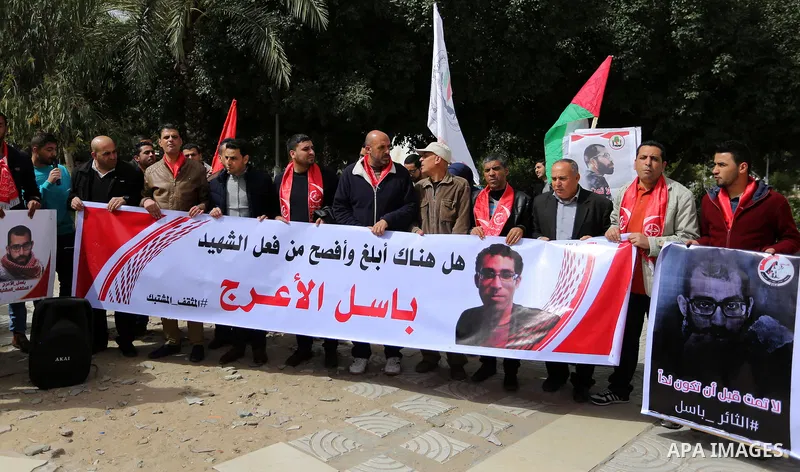 Palestinian supporters of the Popular Front for the Liberation of Palestine (PFLP), hold placards during a protest against the trial of the martyr, Bassel al-Aaraj, and the security coordination in Gaza City, on March 12...