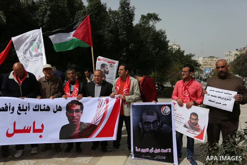 Palestinian supporters of the Popular Front for the Liberation of Palestine (PFLP), hold placards during a protest against the trial of the martyr, Bassel al-Aaraj, and the security coordination in Gaza City, on March 12...