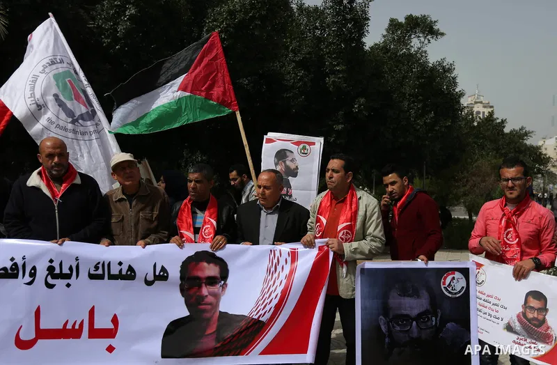 Palestinian supporters of the Popular Front for the Liberation of Palestine (PFLP), hold placards during a protest against the trial of the martyr, Bassel al-Aaraj, and the security coordination in Gaza City, on March 12...
