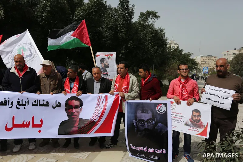 Palestinian supporters of the Popular Front for the Liberation of Palestine (PFLP), hold placards during a protest against the trial of the martyr, Bassel al-Aaraj, and the security coordination in Gaza City, on March 12...