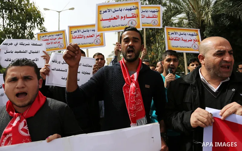Palestinian supporters of the Popular Front for the Liberation of Palestine (PFLP), hold placards during a protest against the trial of the martyr, Bassel al-Aaraj, and the security coordination in Gaza City, on March 12...