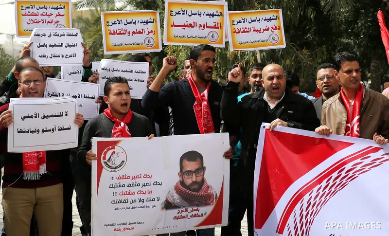 Palestinian supporters of the Popular Front for the Liberation of Palestine (PFLP), hold placards during a protest against the trial of the martyr, Bassel al-Aaraj, and the security coordination in Gaza City, on March 12...