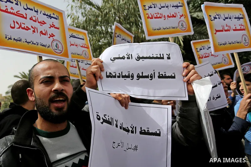 Palestinian supporters of the Popular Front for the Liberation of Palestine (PFLP), hold placards during a protest against the trial of the martyr, Bassel al-Aaraj, and the security coordination in Gaza City, on March 12...