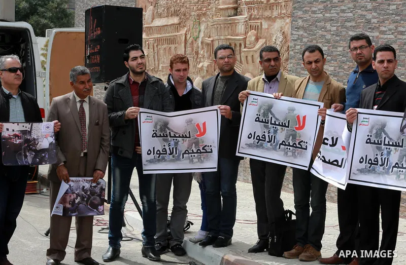 Palestinian journalists hold placards during a protest to show solidarity with their colleges in the West Bank, in front of the Legislative Council, in Gaza city on March 13, 2017. Photo by Mohammed Asad