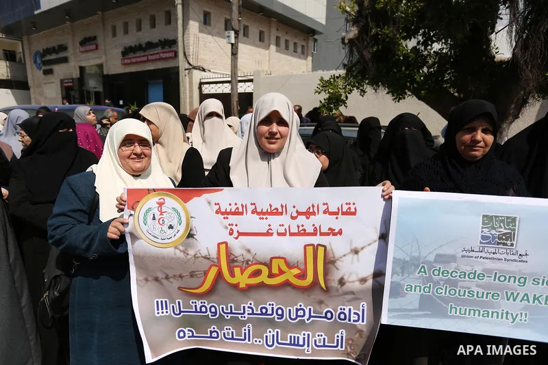 Palestinians hold placards during a protest calling for end the Israeli blockade on Gaza Strip, outside the UN offices, in Gaza city, on March 13, 2017. Photo by Ashraf Amra