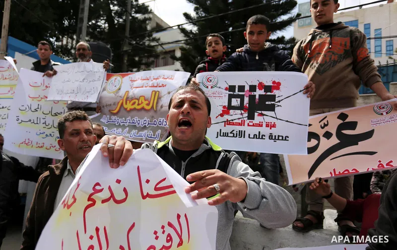 Palestinians hold placards during a protest calling for end the Israeli blockade on Gaza Strip, outside the UN offices, in Gaza city, on March 13, 2017. Photo by Ashraf Amra