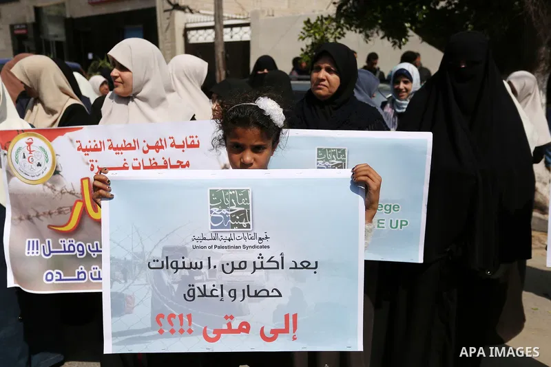 Palestinians hold placards during a protest calling for end the Israeli blockade on Gaza Strip, outside the UN offices, in Gaza city, on March 13, 2017. Photo by Ashraf Amra