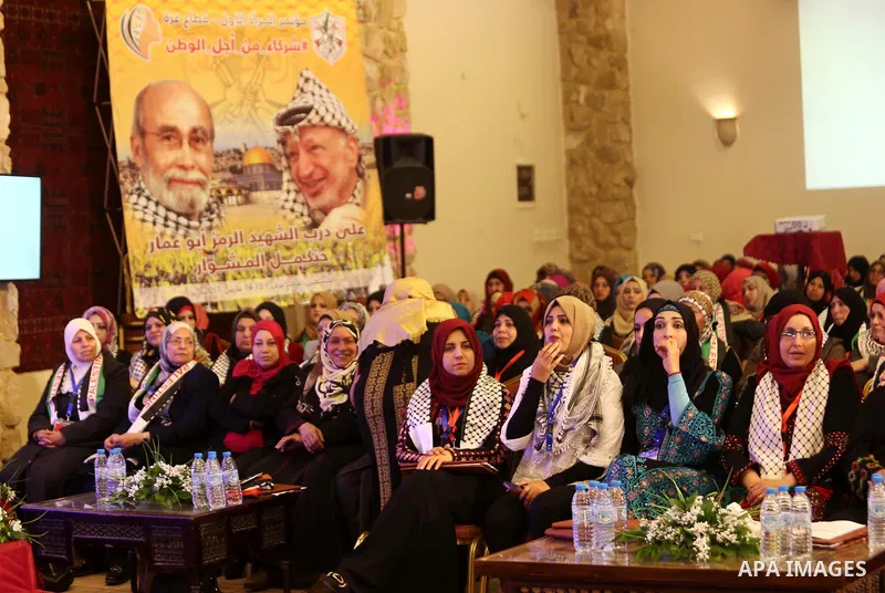 Palestinians listen to Palestinian senior Fatah official Mohammed Dahlan as he gives a speech via a video conference on the first women's conference in Gaza city on March 13, 2017. Photo by Ashraf Amra