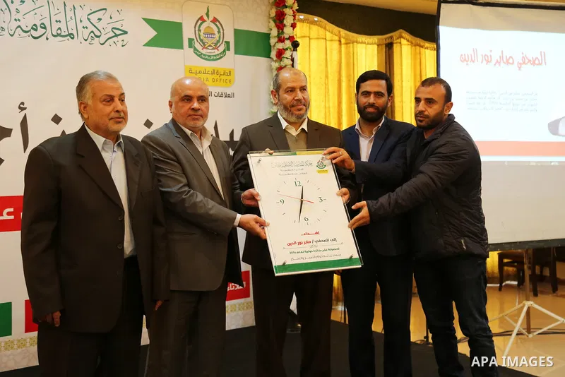 Senior political leader of the Islamist movement Khalil al-Hayah honors a Palestinian journalist who won a world prize at a ceremony, organized by Hamas movement, in Gaza city on March 14, 2017. Photo by Ashraf Amra