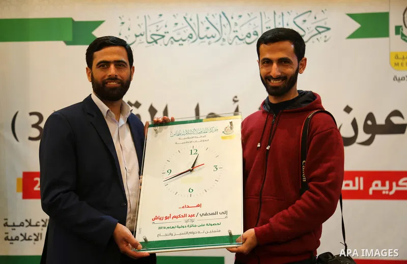 Mushir Al Masri, a Hamas MP and media spokesman honors a Palestinian journalist who won a world prize at a ceremony, organized by Hamas movement, in Gaza city on March 14, 2017. Photo by Ashraf Amra