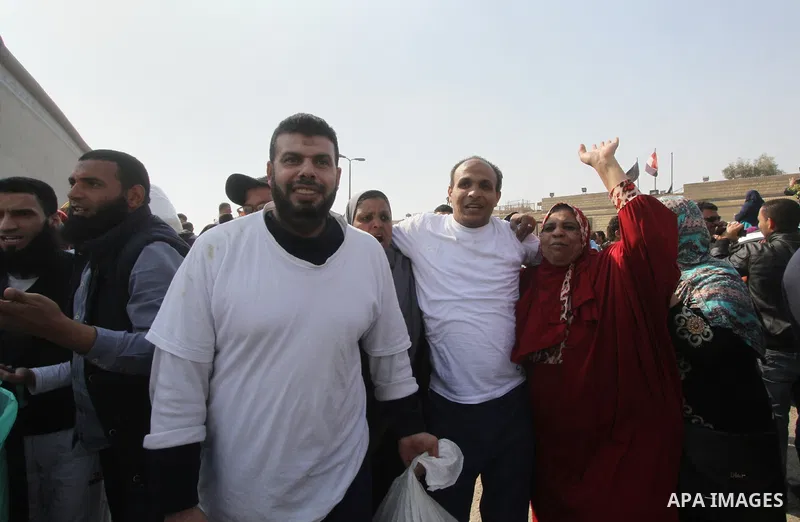 Released detainees wave to their relatives after Egyptian President Abdel Fattah al-Sisi issued a pardon for 203 youths jailed for taking part in demonstrations, as part of a pledge he made months ago to amend a protest...