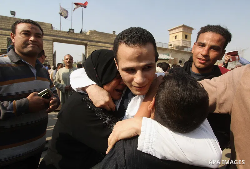 Released detainees wave to their relatives after Egyptian President Abdel Fattah al-Sisi issued a pardon for 203 youths jailed for taking part in demonstrations, as part of a pledge he made months ago to amend a protest...