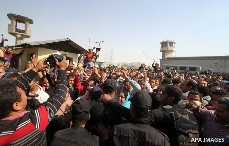 Released detainees wave to their relatives after Egyptian President Abdel Fattah al-Sisi issued a pardon for 203 youths jailed for taking part in demonstrations, as part of a pledge he made months ago to amend a protest...