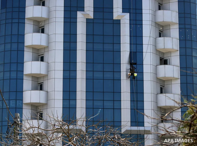 A Palestinian window cleaner hangs from ropes as he cleans windows of Al-zafer tower in Gaza City, in March 15, 2017. Photo by Yasser Qudih