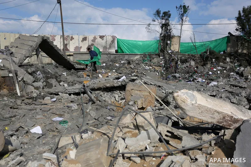 Palestinians look at a Hamas site, which according to the Gaza police, was hit by an Israeli air strike, in Deir El-Balah, in the central Gaza Strip March 16, 2017. Photo by Ashraf Amra