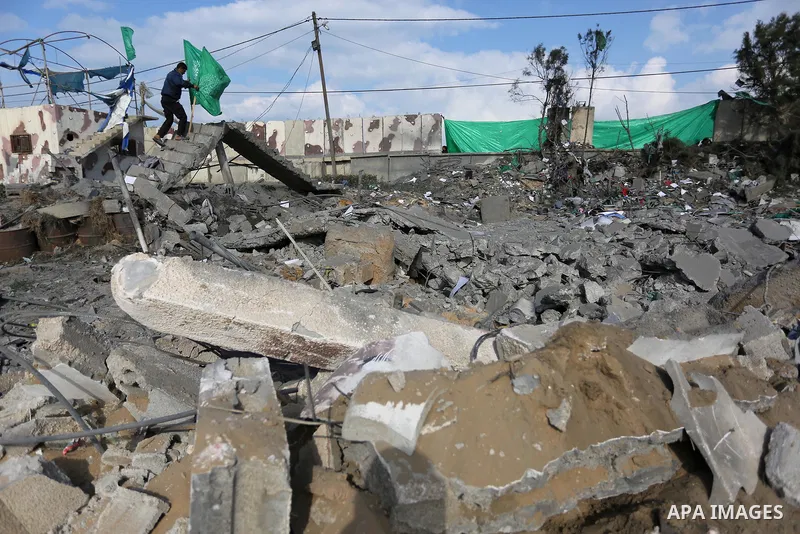 Palestinians look at a Hamas site, which according to the Gaza police, was hit by an Israeli air strike, in Deir El-Balah, in the central Gaza Strip March 16, 2017. Photo by Ashraf Amra