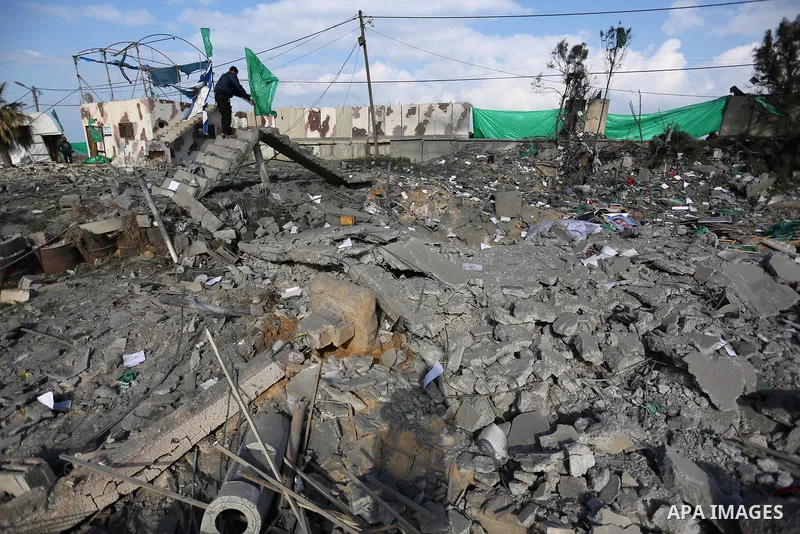 Palestinians look at a Hamas site, which according to the Gaza police, was hit by an Israeli air strike, in Deir El-Balah, in the central Gaza Strip March 16, 2017. Photo by Ashraf Amra