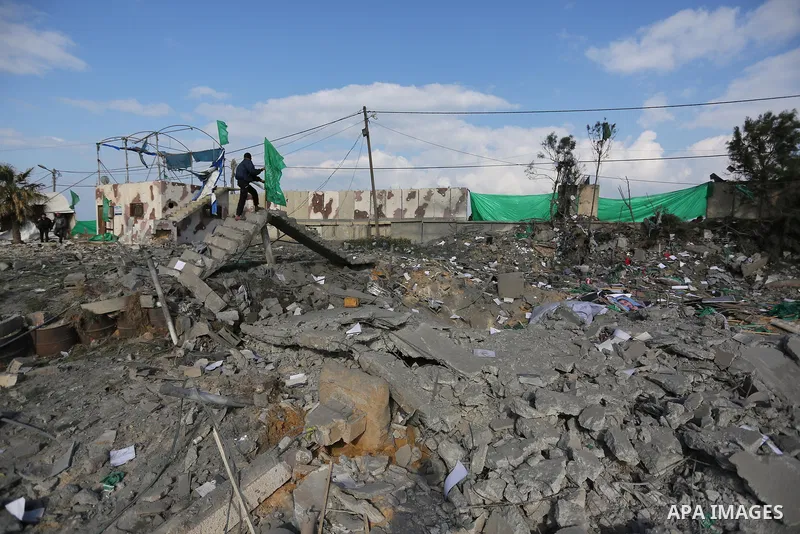 Palestinians look at a Hamas site, which according to the Gaza police, was hit by an Israeli air strike, in Deir El-Balah, in the central Gaza Strip March 16, 2017. Photo by Ashraf Amra
