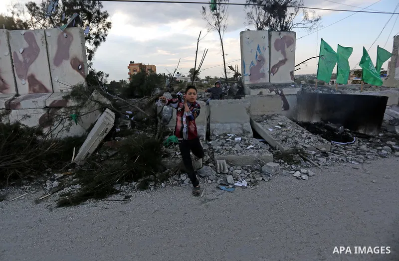 Palestinians look at a Hamas site, which according to the Gaza police, was hit by an Israeli air strike, in Deir El-Balah, in the central Gaza Strip March 16, 2017. Photo by Ashraf Amra