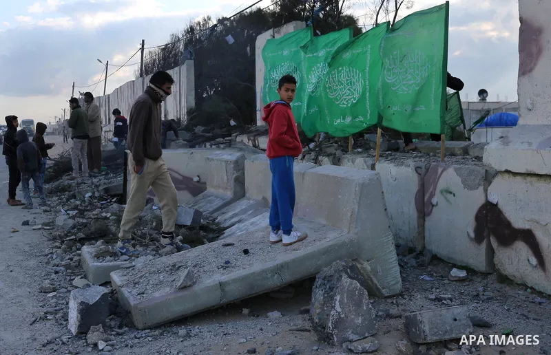Palestinians look at a Hamas site, which according to the Gaza police, was hit by an Israeli air strike, in Deir El-Balah, in the central Gaza Strip March 16, 2017. Photo by Ashraf Amra