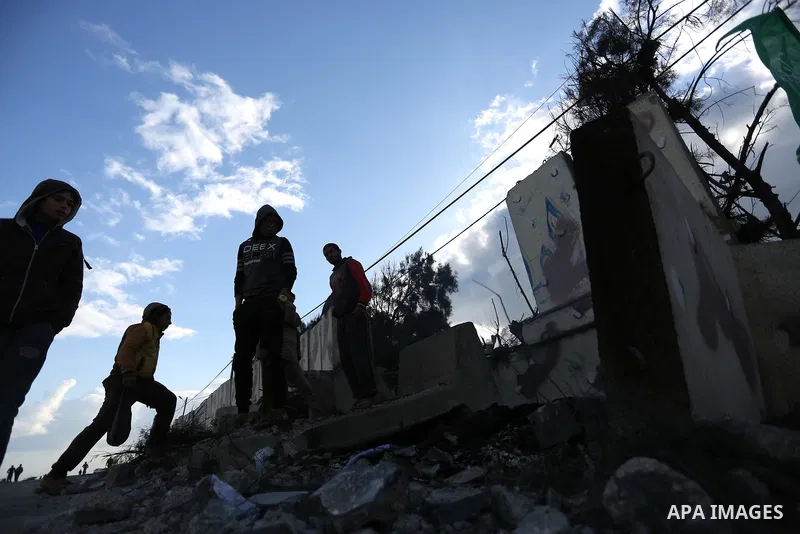 Palestinians look at a Hamas site, which according to the Gaza police, was hit by an Israeli air strike, in Deir El-Balah, in the central Gaza Strip March 16, 2017. Photo by Ashraf Amra
