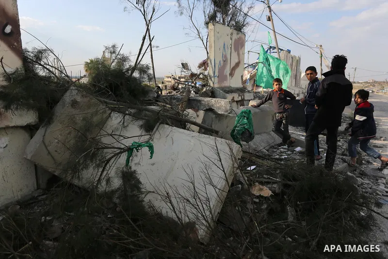 Palestinians look at a Hamas site, which according to the Gaza police, was hit by an Israeli air strike, in Deir El-Balah, in the central Gaza Strip March 16, 2017. Photo by Ashraf Amra