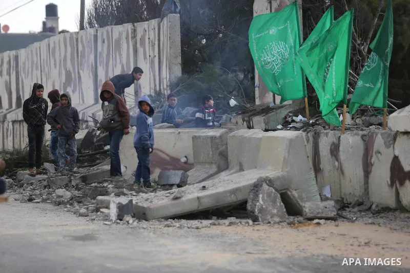 Palestinians look at a Hamas site, which according to the Gaza police, was hit by an Israeli air strike, in Deir El-Balah, in the central Gaza Strip March 16, 2017. Photo by Ashraf Amra
