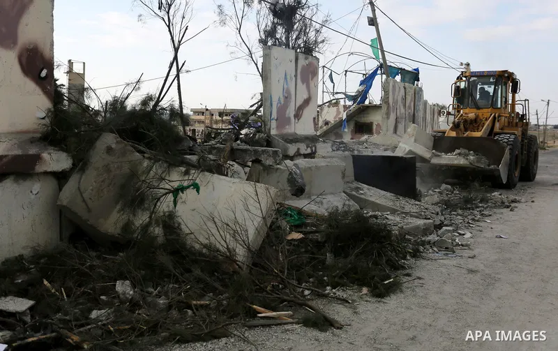 A Palestinian bulldozer demolishes a Hamas site, which according to the Gaza police, was hit by an Israeli air strike, in Deir El-Balah, in the central Gaza Strip March 16, 2017. Photo by Ashraf Amra