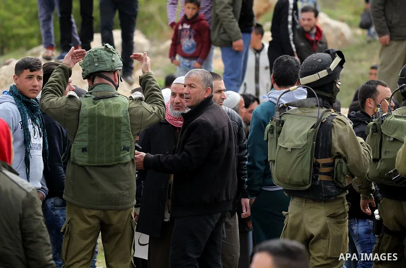 An Israeli soldier argues with a Palestinian protester during a protest calling for the reopening of a closed street in the West Bank city of Hebron on March 17, 2017. Photo by Wisam Hashlamoun