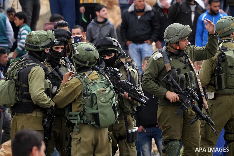 Israeli soldiers take position during a protest by Palestinians calling for the reopening of a closed street in the West Bank city of Hebron on March 17, 2017. Photo by Wisam Hashlamoun