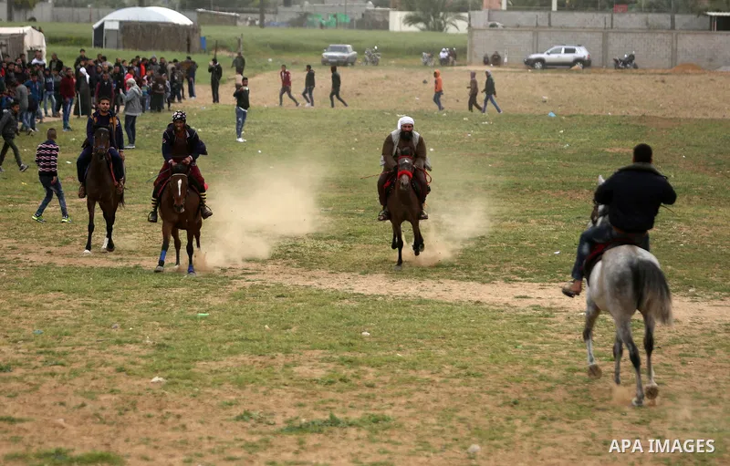 Palestinians ride horses during a heritage festival in Zawayda in the central Gaza Strip March 17, 2017. Photo by Ashraf Amra