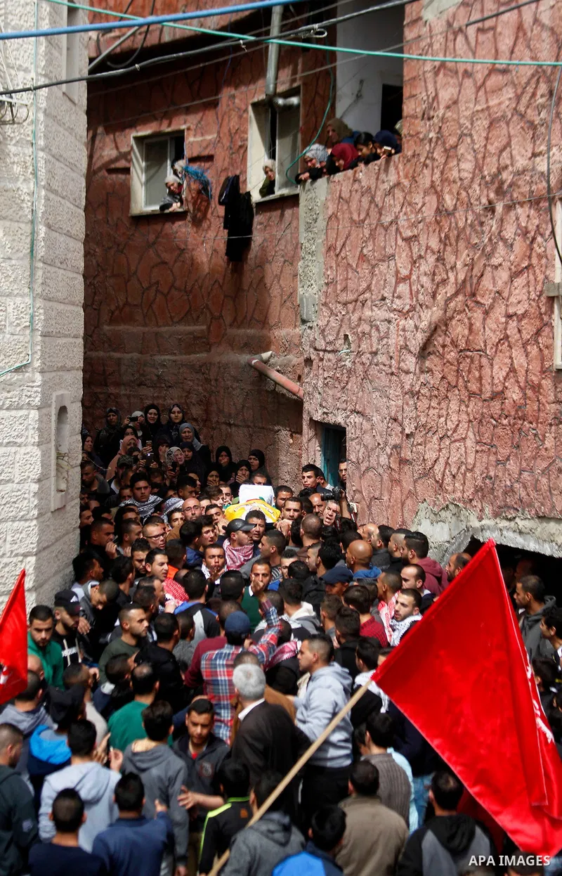 Mourners carry the body of Palestinian youth Morad Abu Ghazi, 16, who was killed by Israeli troops during clashes, during his funeral in al-Arroub refugee camp near the West Bank city of Hebron March 18, 2017. Photo by W...