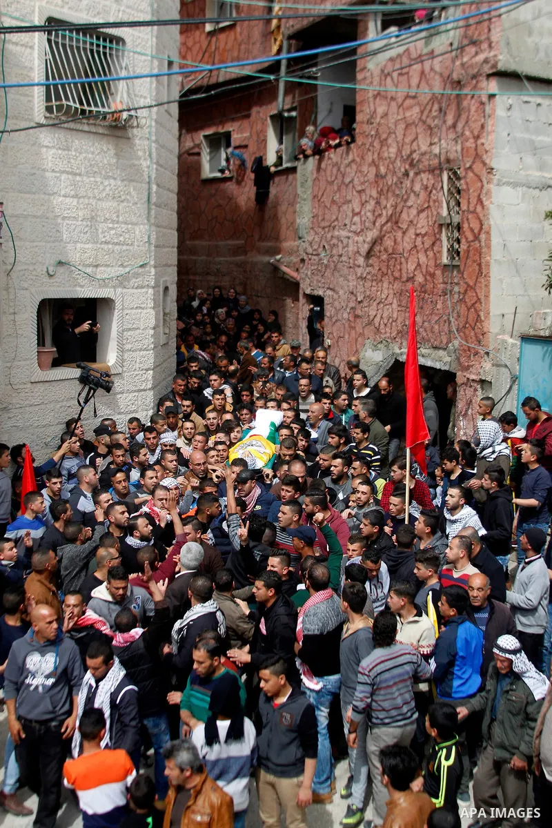 Mourners carry the body of Palestinian youth Morad Abu Ghazi, 16, who was killed by Israeli troops during clashes, during his funeral in al-Arroub refugee camp near the West Bank city of Hebron March 18, 2017. Photo by W...
