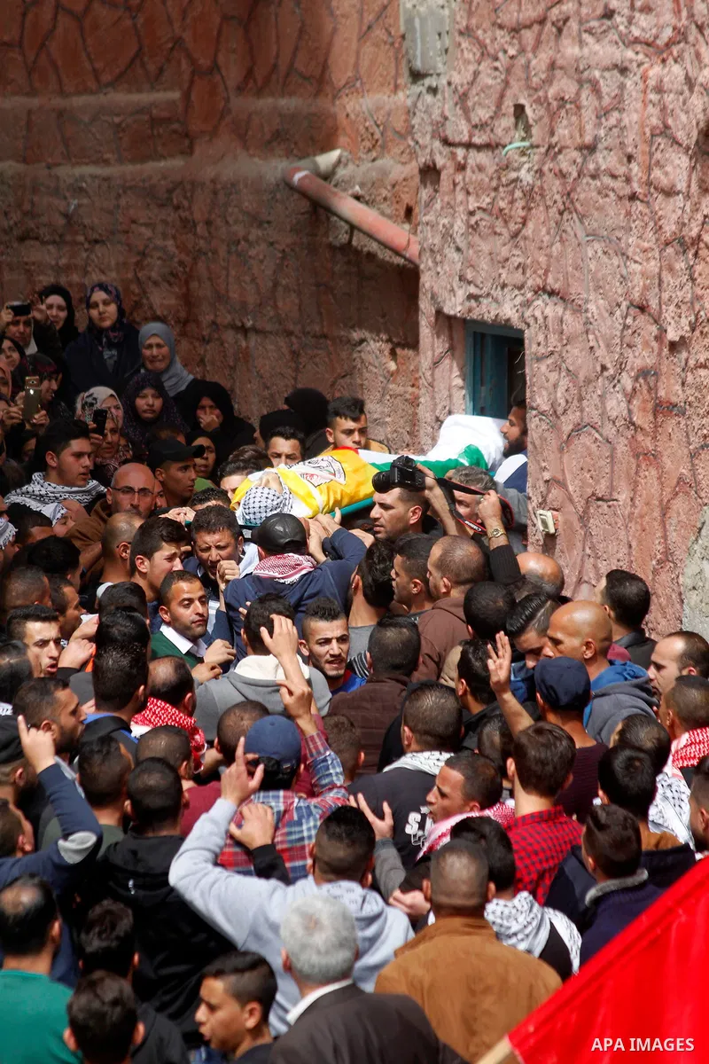 Mourners carry the body of Palestinian youth Morad Abu Ghazi, 16, who was killed by Israeli troops during clashes, during his funeral in al-Arroub refugee camp near the West Bank city of Hebron March 18, 2017. Photo by W...