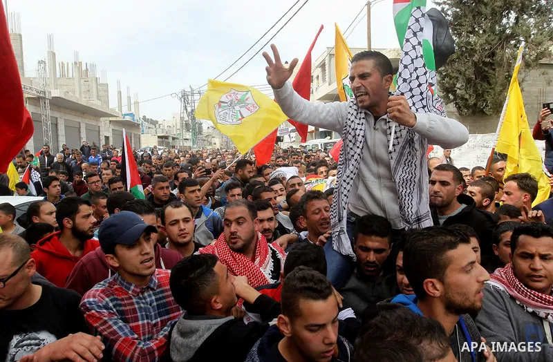 Mourners carry the body of Palestinian youth Morad Abu Ghazi, 16, who was killed by Israeli troops during clashes, during his funeral in al-Arroub refugee camp near the West Bank city of Hebron March 18, 2017. Photo by W...