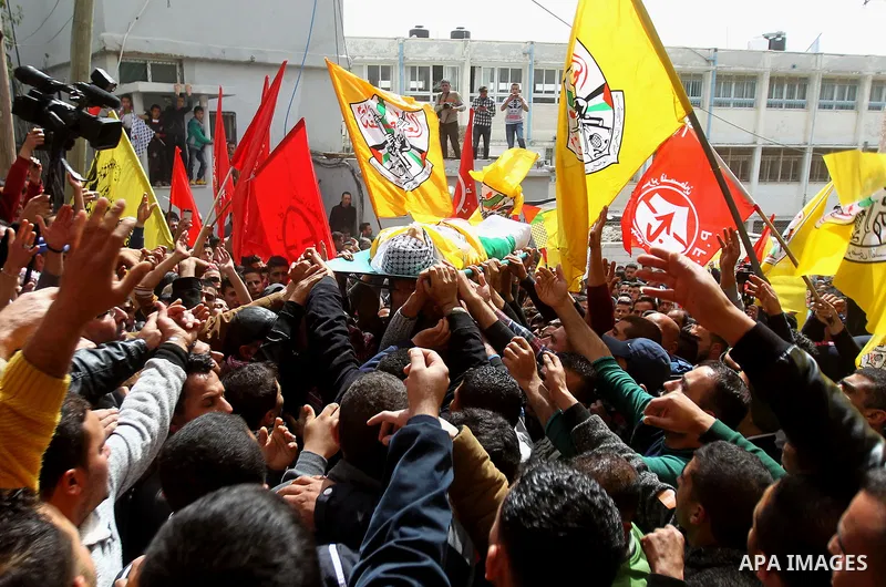 Mourners carry the body of Palestinian youth Morad Abu Ghazi, 16, who was killed by Israeli troops during clashes, during his funeral in al-Arroub refugee camp near the West Bank city of Hebron March 18, 2017. Photo by W...