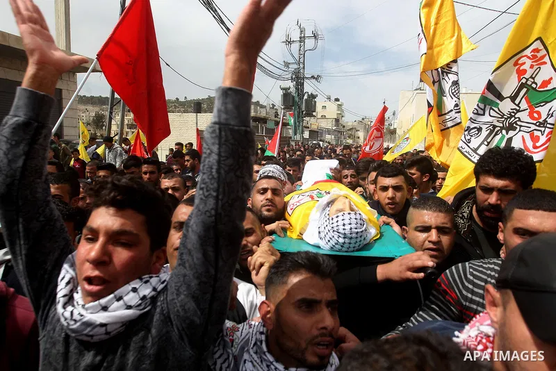 Mourners carry the body of Palestinian youth Morad Abu Ghazi, 16, who was killed by Israeli troops during clashes, during his funeral in al-Arroub refugee camp near the West Bank city of Hebron March 18, 2017. Photo by W...