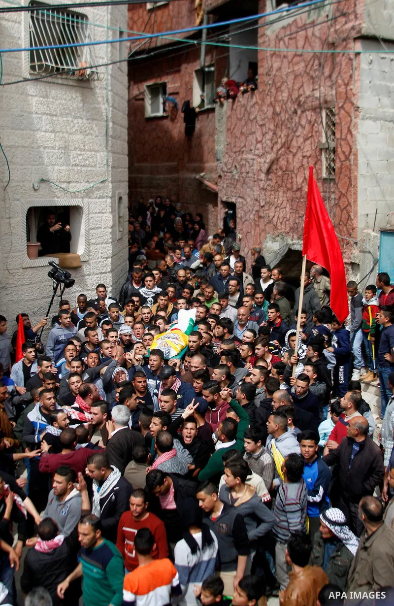 Mourners carry the body of Palestinian youth Morad Abu Ghazi, 16, who was killed by Israeli troops during clashes, during his funeral in al-Arroub refugee camp near the West Bank city of Hebron March 18, 2017. Photo by W...